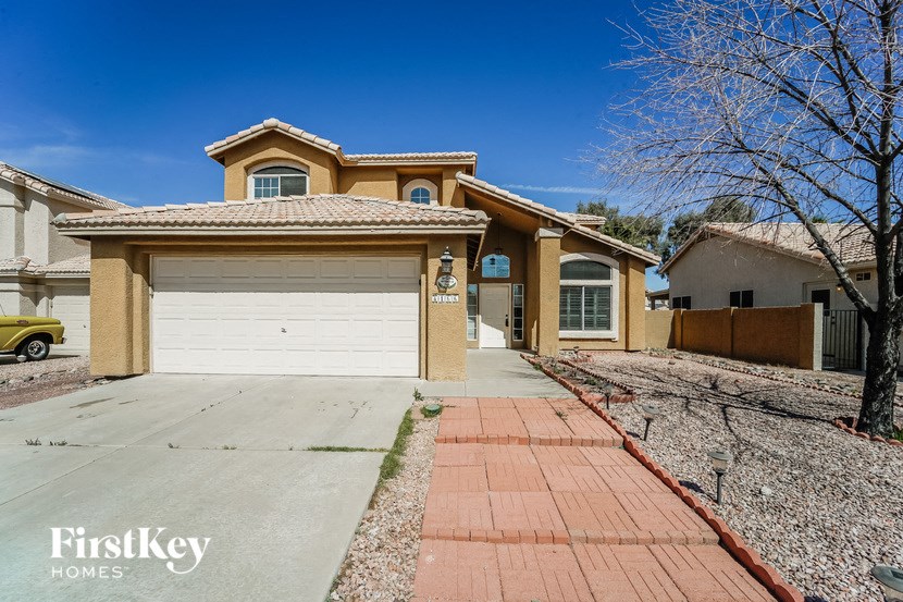 A house with a garage and a driveway in front of it.