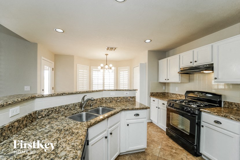A kitchen with granite countertops and white cabinets.