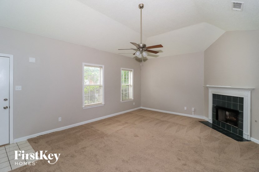 a living room with a fireplace and a ceiling fan