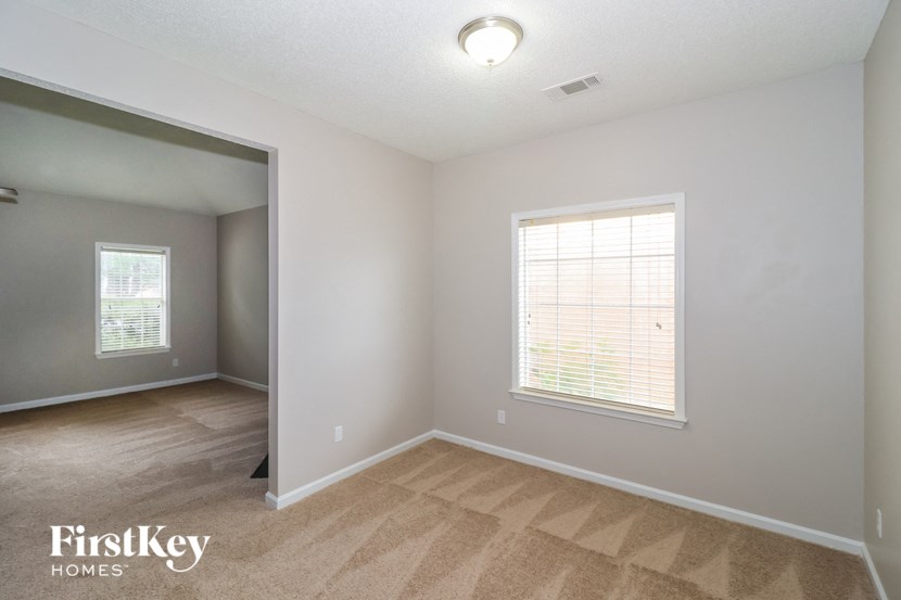 the spacious living room with hardwood flooring and a large window