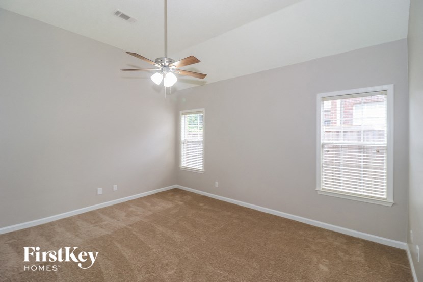 a bedroom with carpet and a ceiling fan