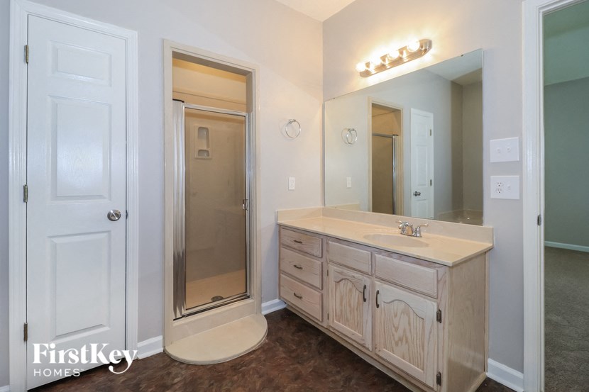 the master bathroom has a large vanity and a shower