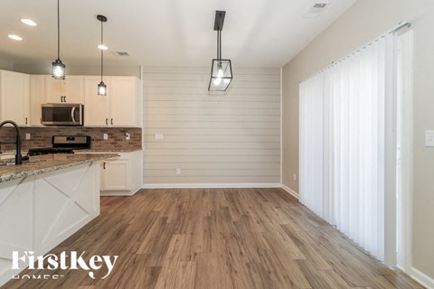 A kitchen with wooden floors and a countertop with a microwave on it.