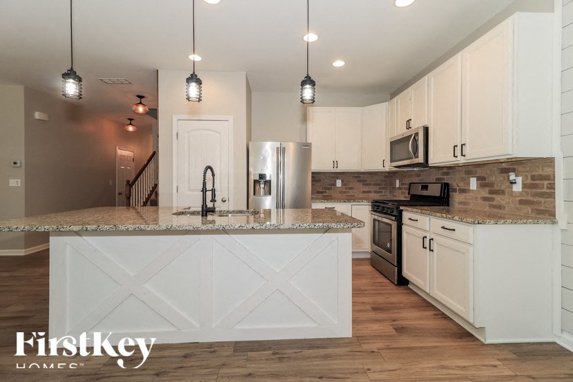 A kitchen with a white island and wooden cabinets.