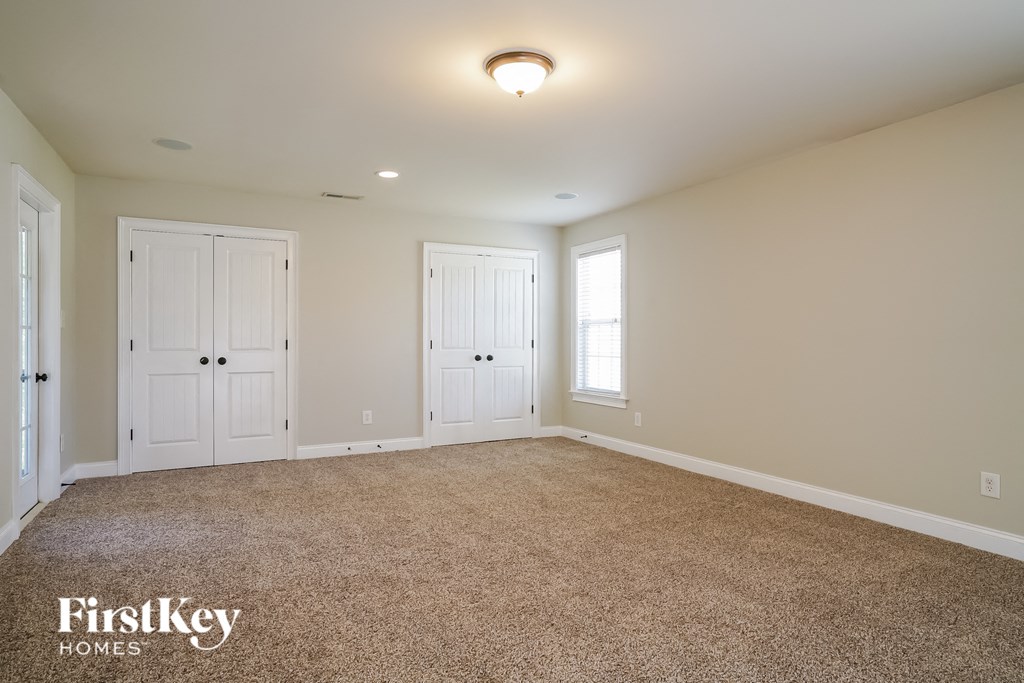 the master bedroom has a carpeted floor and two closets