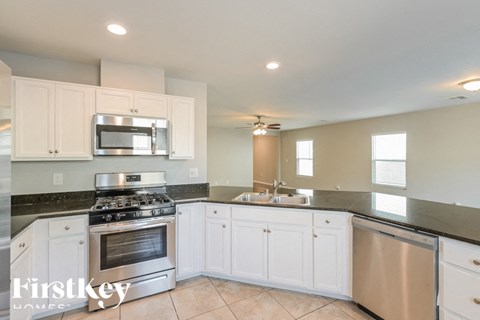 A kitchen with white cabinets and a stainless steel oven.