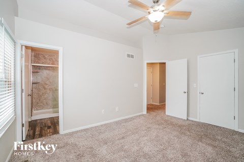 a living room with carpet and a ceiling fan