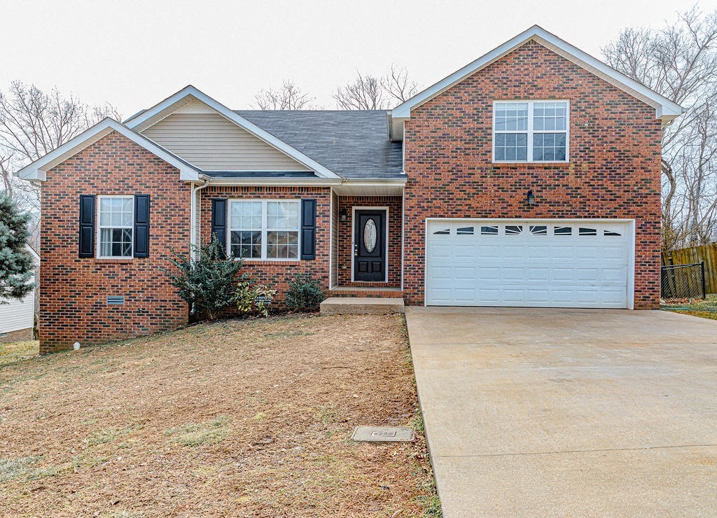 a brick house with a white garage door and a driveway