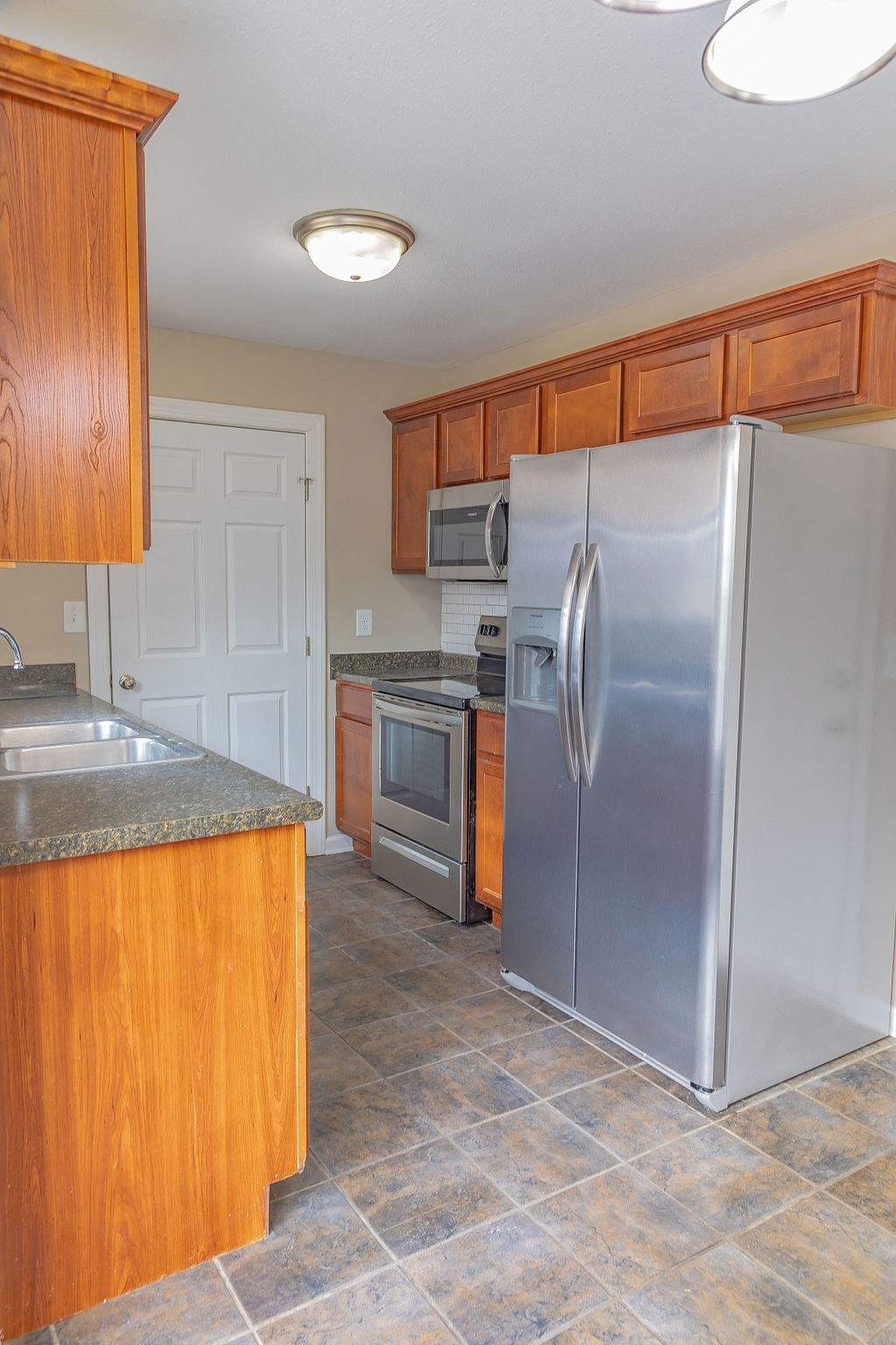 a kitchen with stainless steel appliances and wooden cabinets