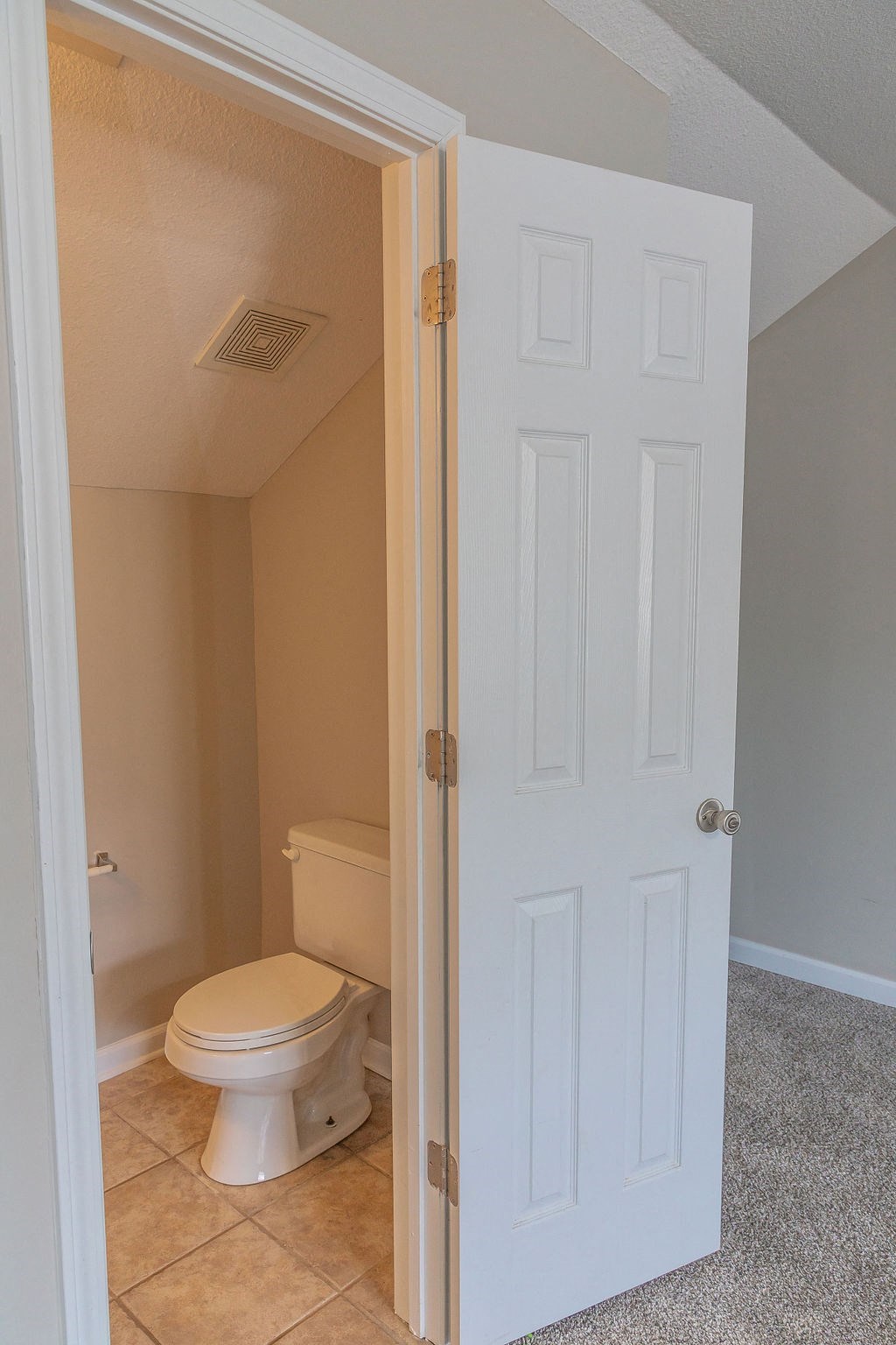 a bathroom with a toilet and a white door