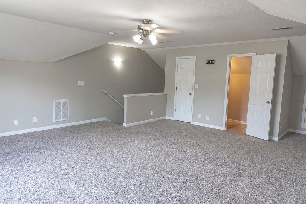 an empty living room with a ceiling fan