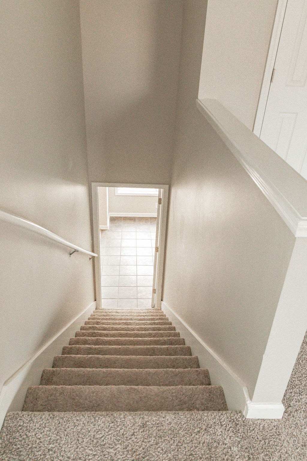 a view of the stairs from the bottom of the staircase looking up to the hallway