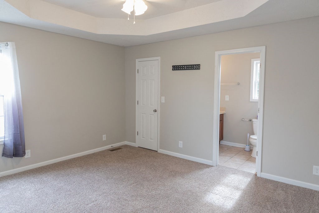 a empty living room with a door to a bathroom