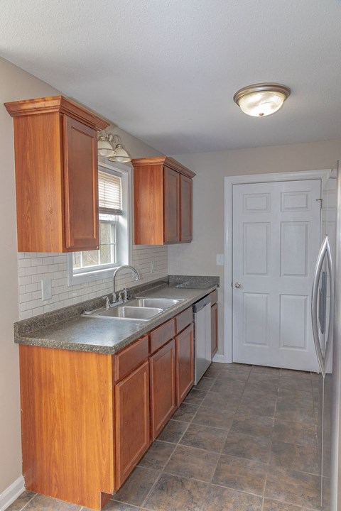 a kitchen with wooden cabinets and a sink and a refrigerator