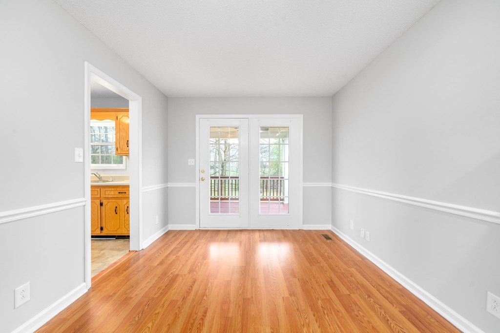 an empty living room with white walls and wood floors
