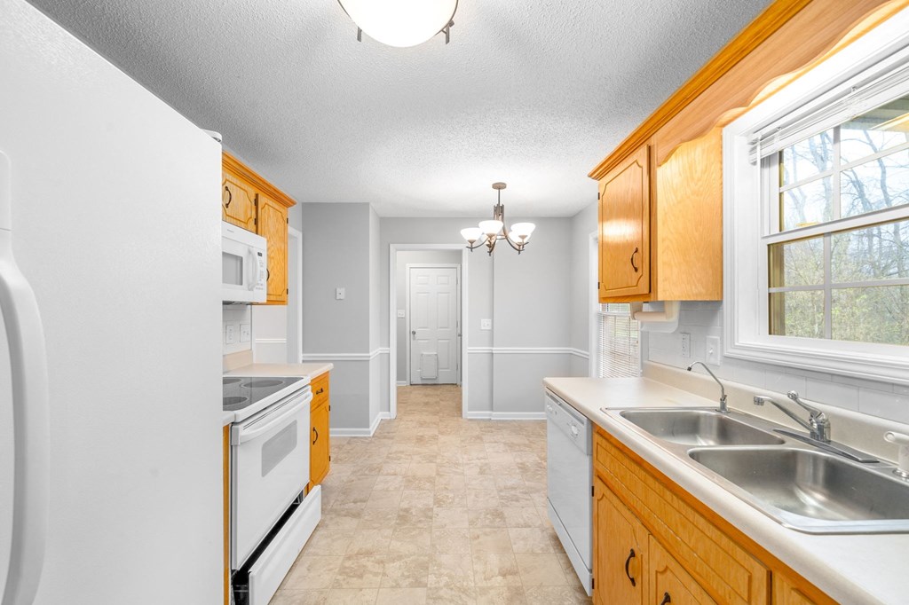 a kitchen with white appliances and wooden cabinets