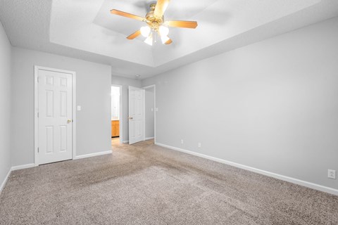 a living room with carpet and a ceiling fan