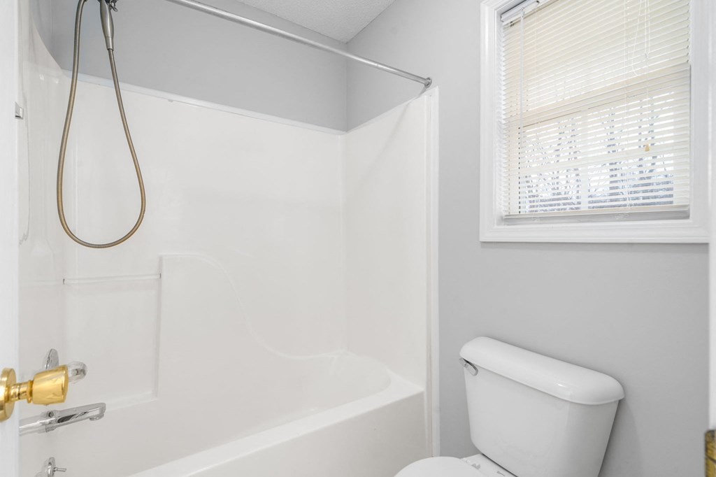 a white bathroom with a shower and a toilet
