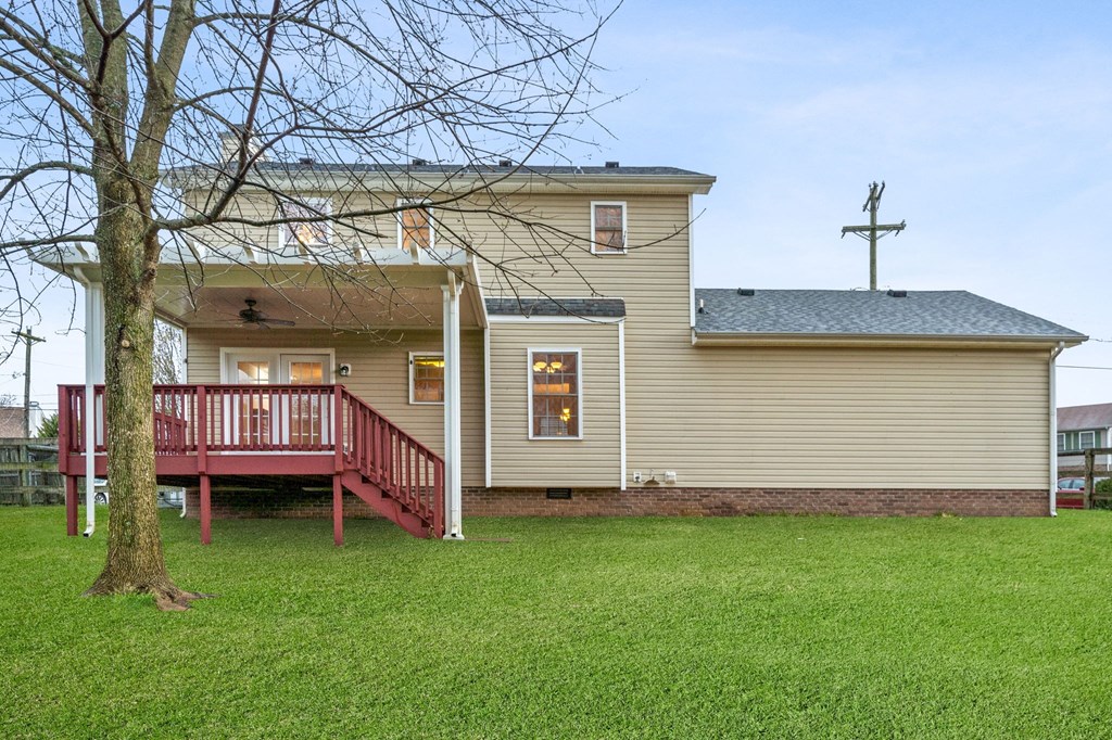 a yellow church with a red porch and a tree