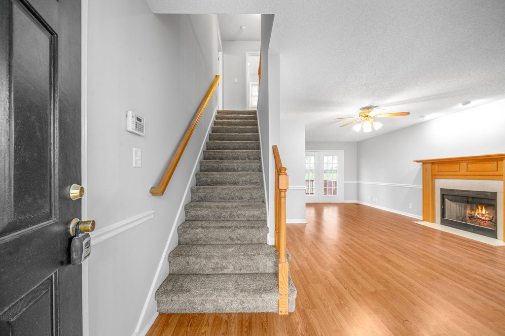 a staircase leading up to a living room with a fireplace