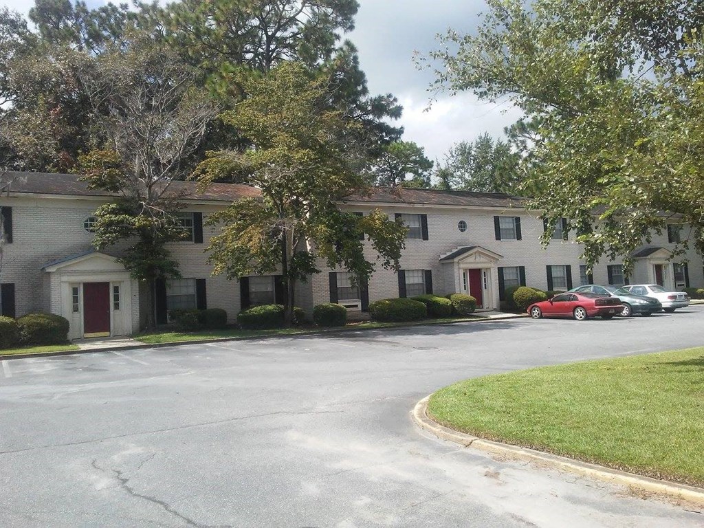 a large white house with cars parked in front of it