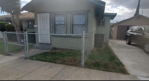 a house with a fence and a car parked in front of it