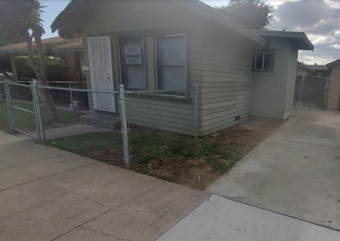 a house with a fenced in yard and a chain link fence