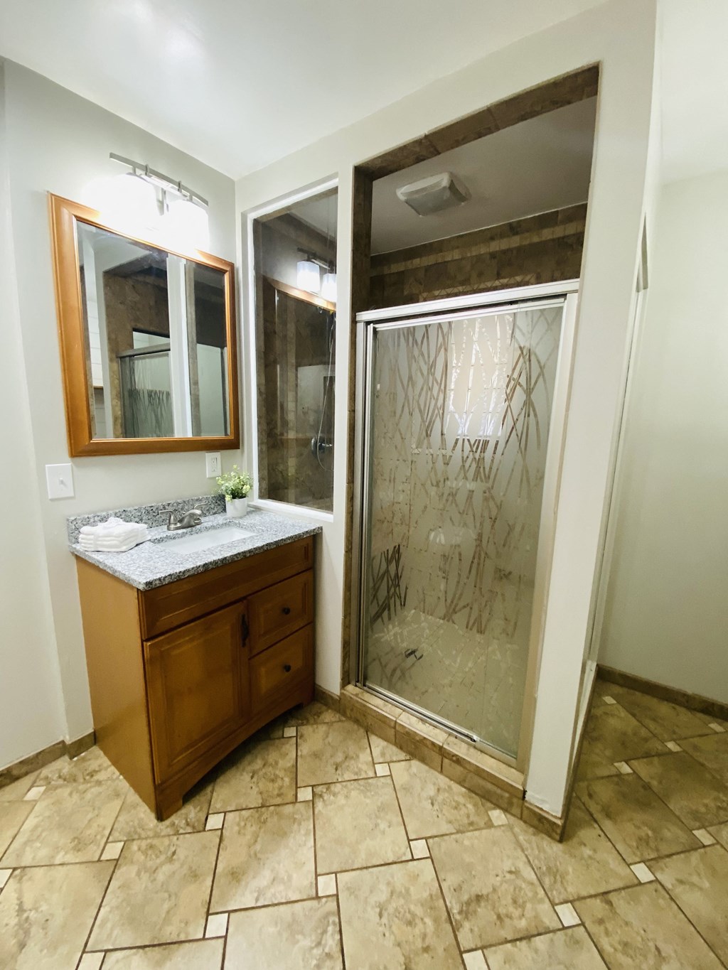 a bathroom with a shower and a sink and a mirror