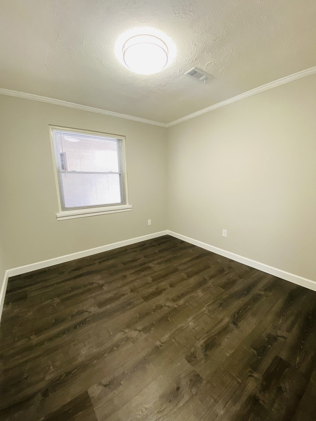 an empty room with wooden floors and a window