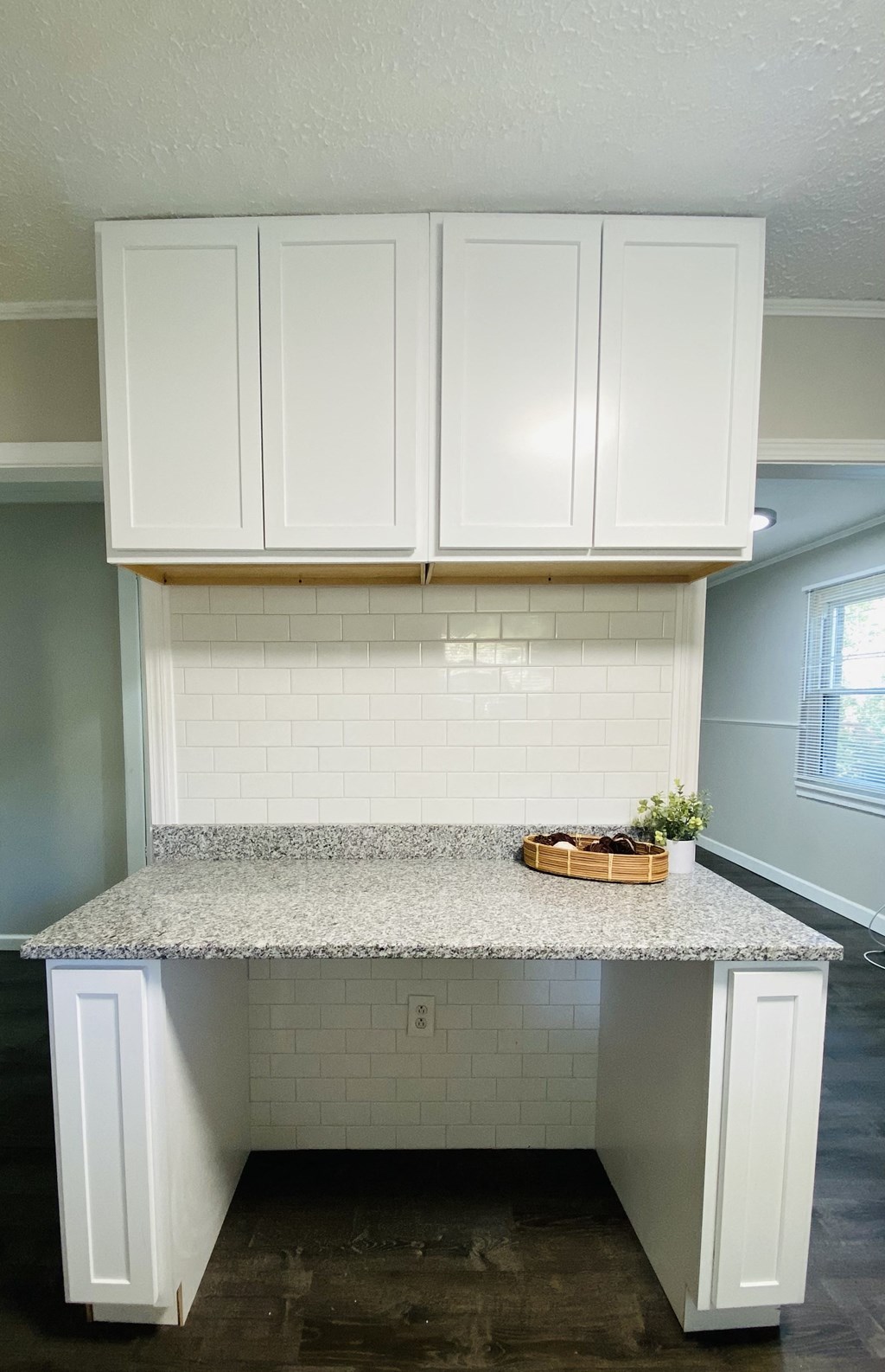 a white kitchen with white cabinets and a counter top