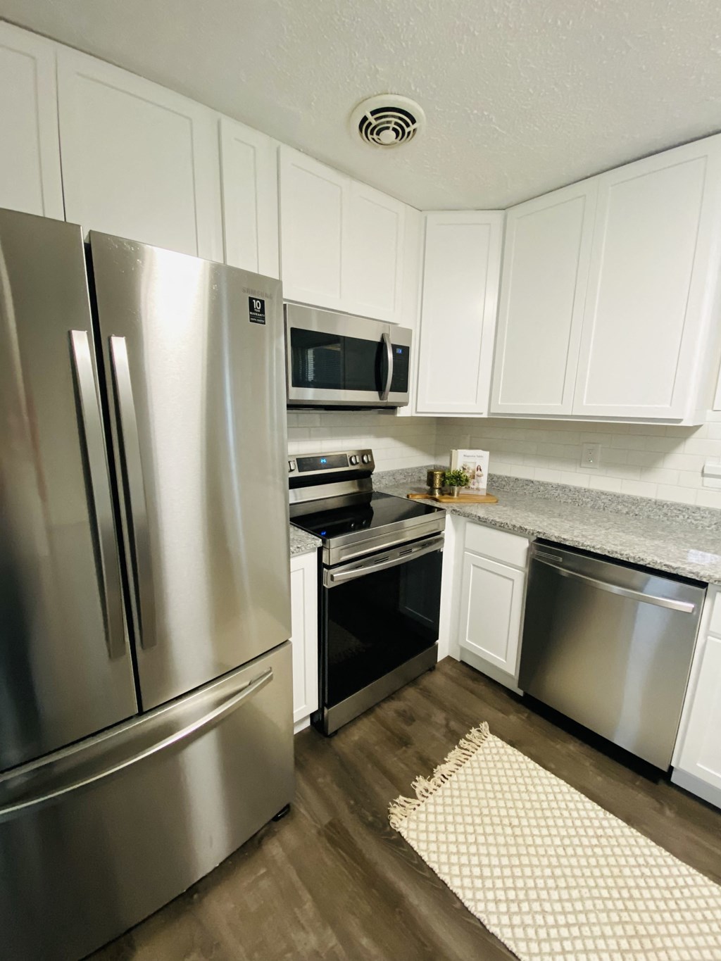 a kitchen with stainless steel appliances and white cabinets