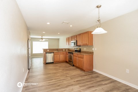 a kitchen with wood flooring and wooden cabinets