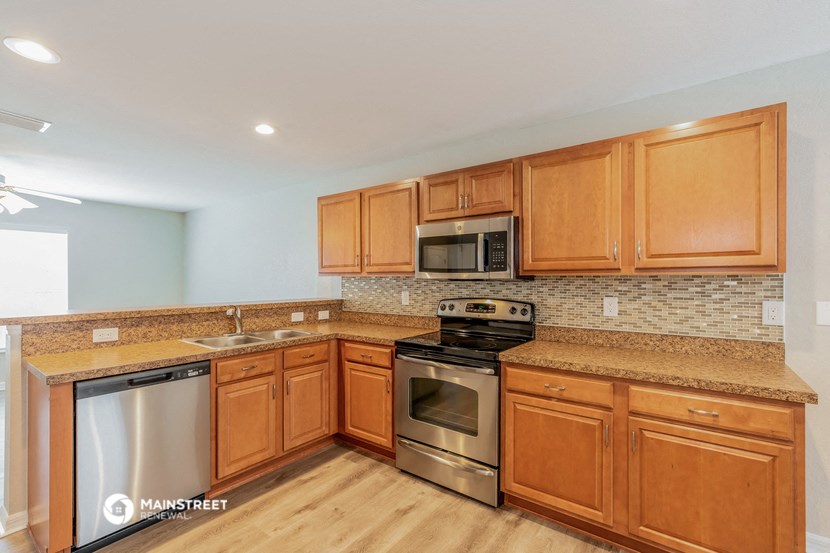 a kitchen with wooden cabinets and stainless steel appliances