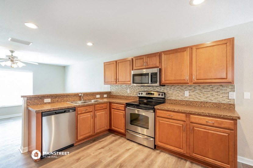 a kitchen with wooden cabinets and stainless steel appliances