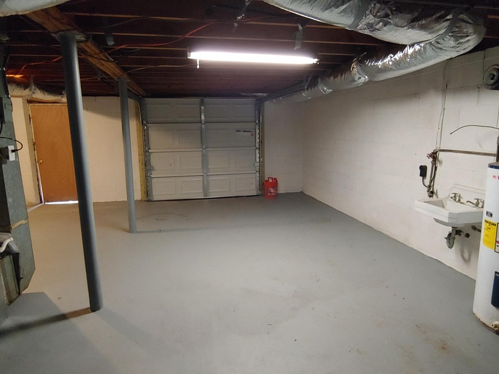 the inside of a basement with a sink and a garage door