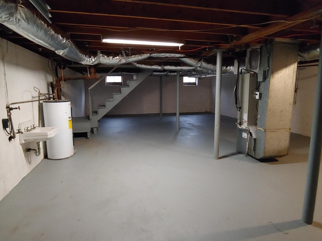 a large basement with a sink and a staircase