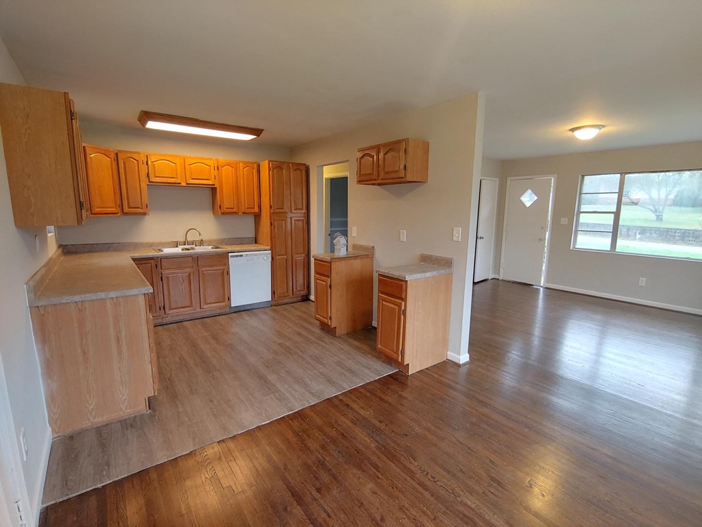 an empty kitchen with wooden floors and wooden cabinets