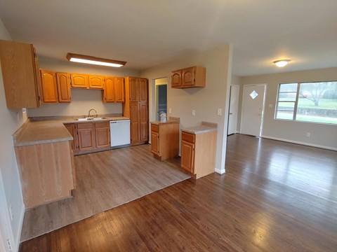 an empty kitchen with wooden floors and wooden cabinets