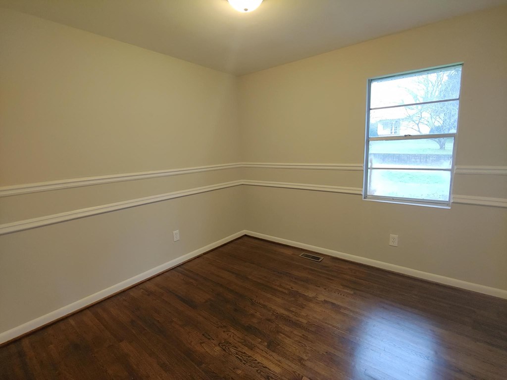 a empty room with wooden floors and a window