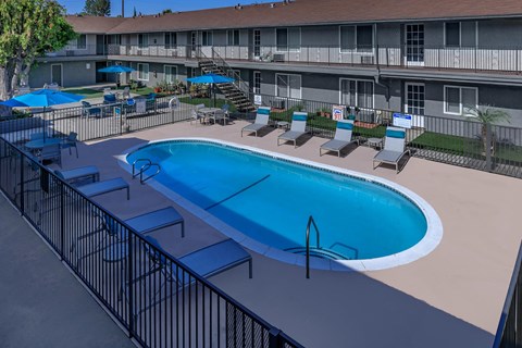 a large swimming pool in front of a hotel building