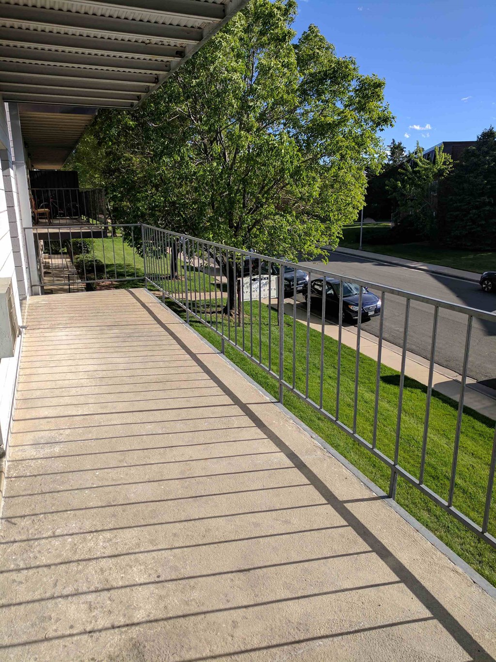 a porch with a metal fence on the side of a house