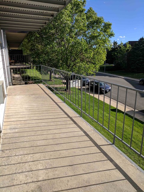 a porch with a metal fence on the side of a house