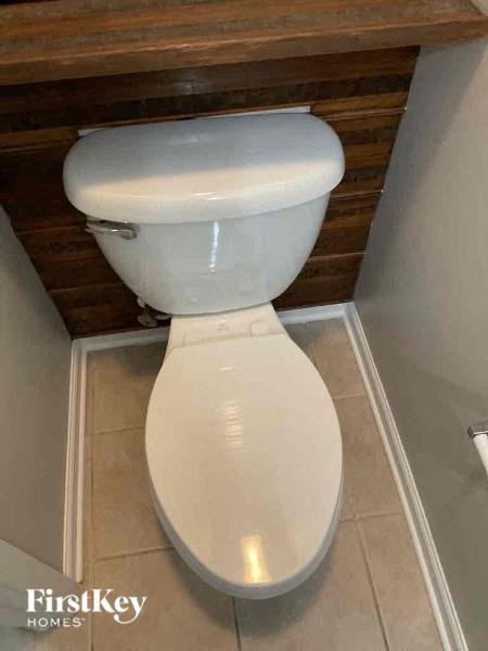 a white toilet in a bathroom with a wooden ceiling