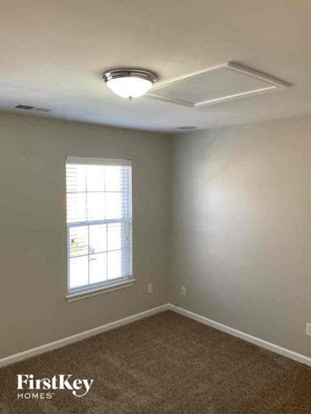an empty bedroom with a ceiling fan and a window