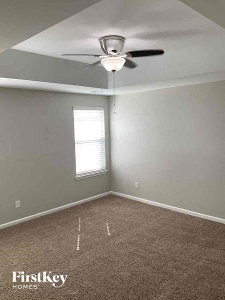 an empty room with a ceiling fan and a window