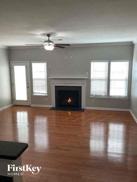 an empty living room with a fireplace and a ceiling fan