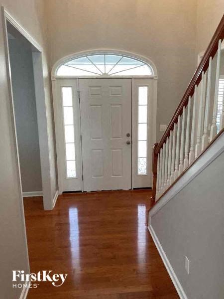 a hallway of a house with a door and a staircase