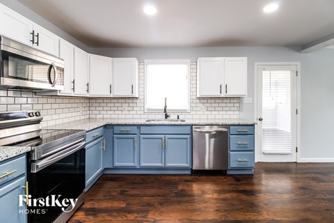 A kitchen with blue cabinets and a stainless steel dishwasher.