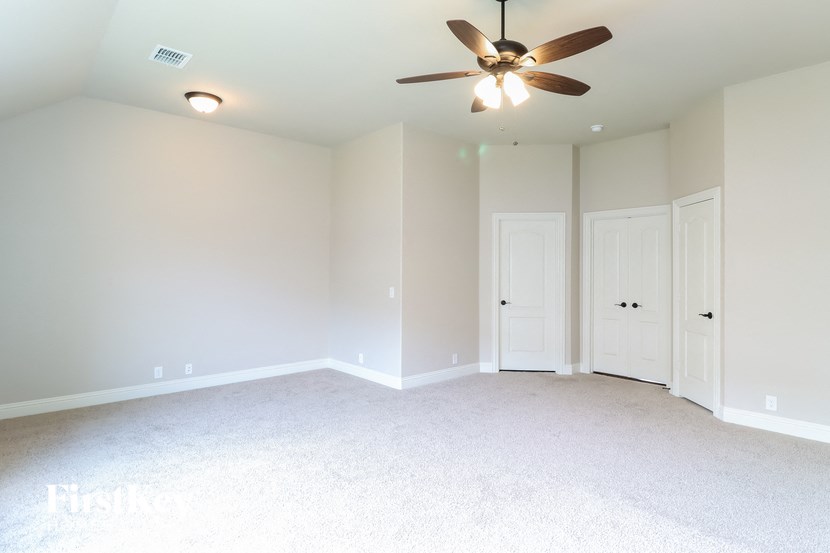 a bedroom with white carpet and a ceiling fan
