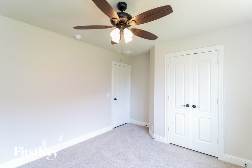 a bedroom with a ceiling fan and a closet